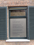 840655 Afbeelding van het gedicht 'Wolvenplein' van Peter Drehmanns in een venster van de voormalige strafgevangenis ...